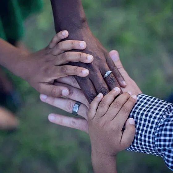 People putting their hands together to represent teamwork.