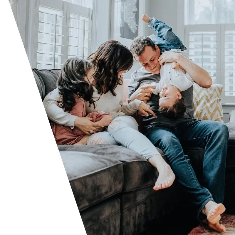 A family brought together having fun on the couch.